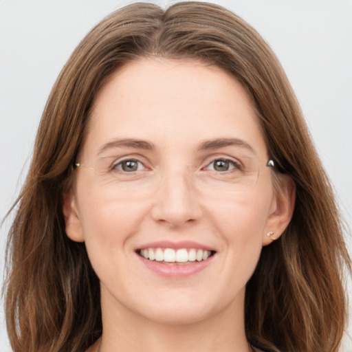 Joyful white young-adult female with long  brown hair and grey eyes