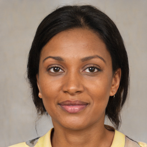 Joyful black young-adult female with medium  brown hair and brown eyes