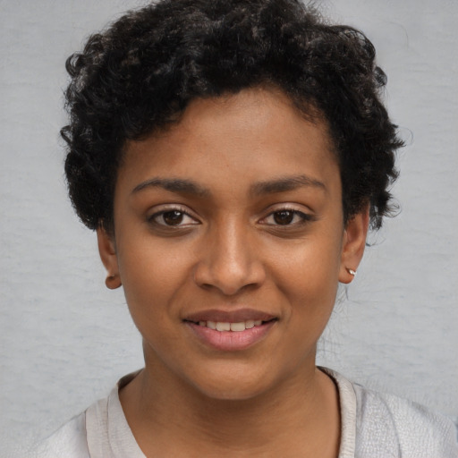Joyful black child female with short  black hair and brown eyes