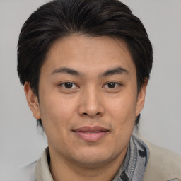 Joyful asian young-adult male with short  brown hair and brown eyes