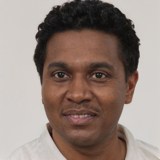 Joyful black adult male with short  black hair and brown eyes