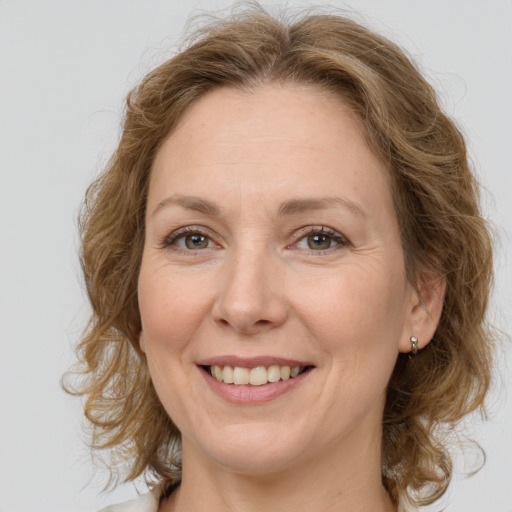 Joyful white adult female with medium  brown hair and green eyes