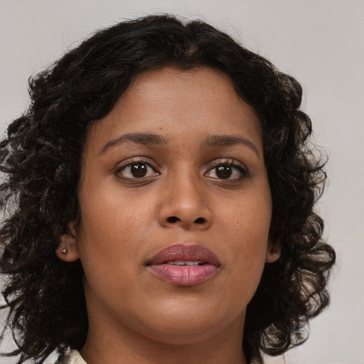 Joyful black young-adult female with medium  brown hair and brown eyes