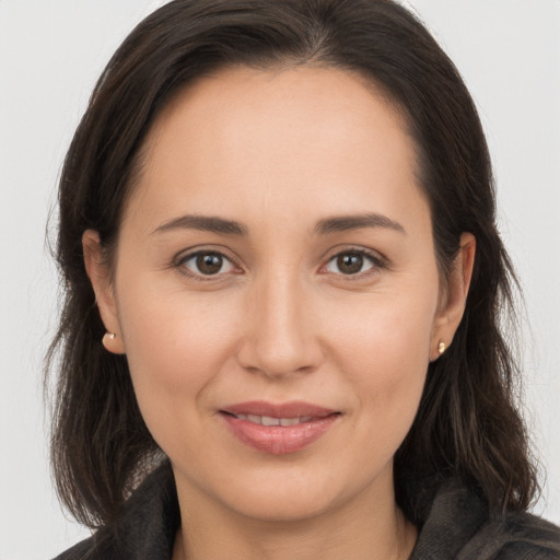 Joyful white young-adult female with long  brown hair and brown eyes