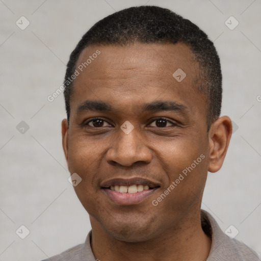 Joyful black young-adult male with short  black hair and brown eyes