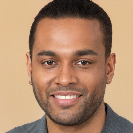 Joyful black young-adult male with short  brown hair and brown eyes