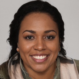 Joyful black young-adult female with long  brown hair and brown eyes