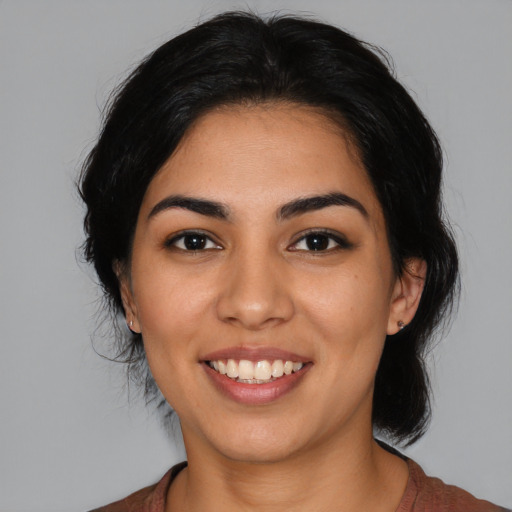 Joyful latino young-adult female with medium  black hair and brown eyes
