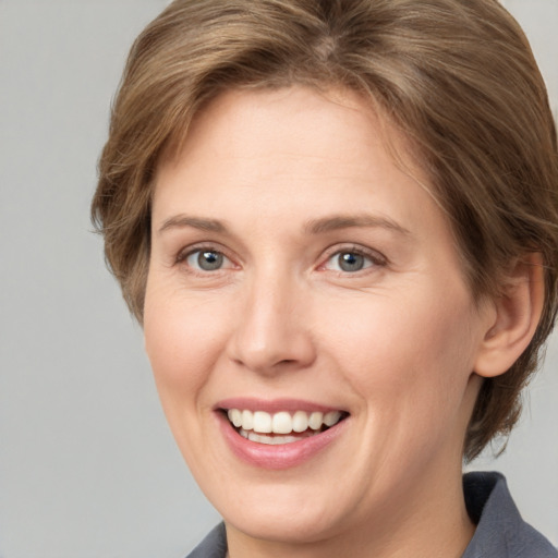 Joyful white adult female with medium  brown hair and grey eyes