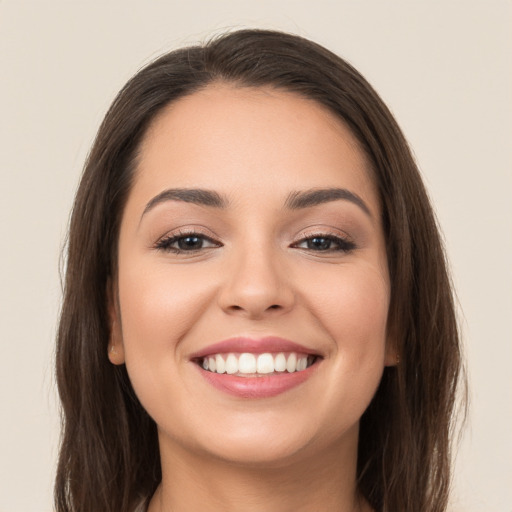 Joyful white young-adult female with long  brown hair and brown eyes