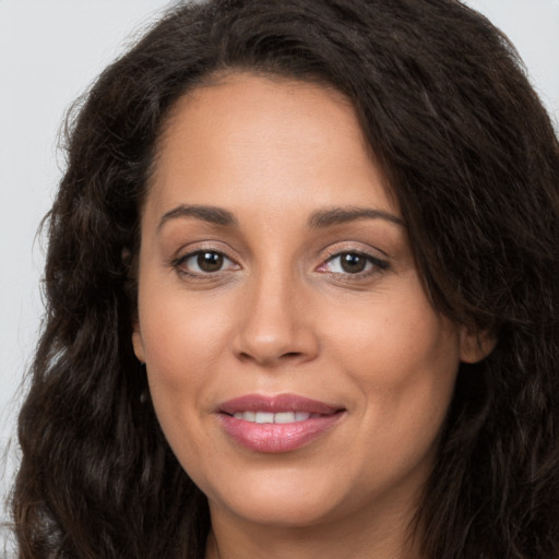 Joyful white young-adult female with long  brown hair and brown eyes