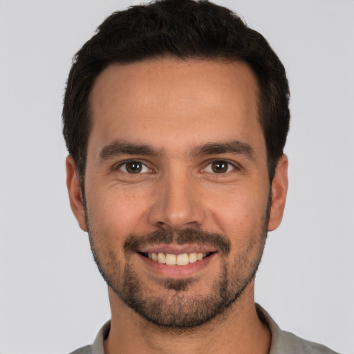 Joyful white young-adult male with short  black hair and brown eyes