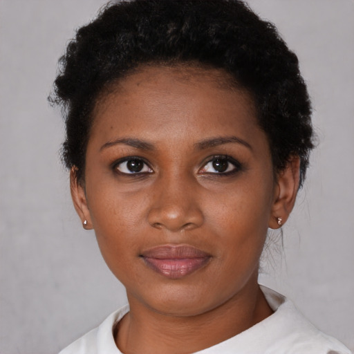 Joyful black young-adult female with short  brown hair and brown eyes