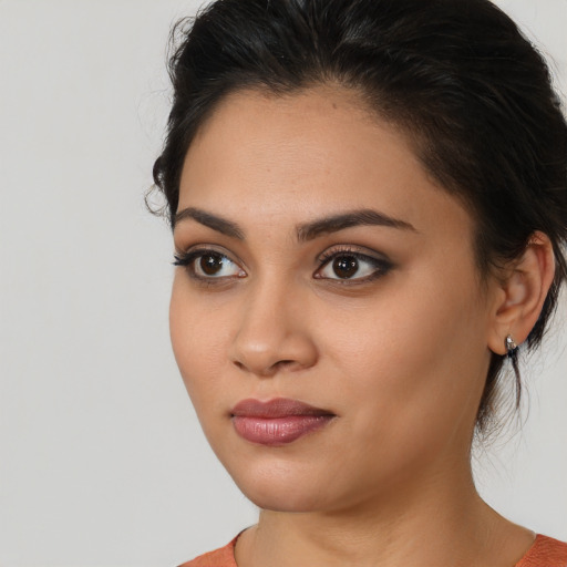 Joyful latino young-adult female with medium  brown hair and brown eyes