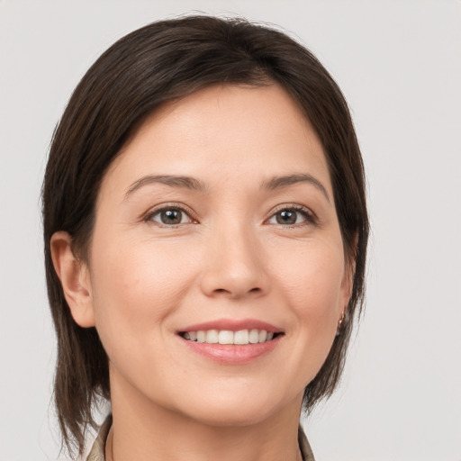 Joyful white young-adult female with medium  brown hair and brown eyes