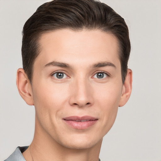 Joyful white young-adult male with short  brown hair and grey eyes