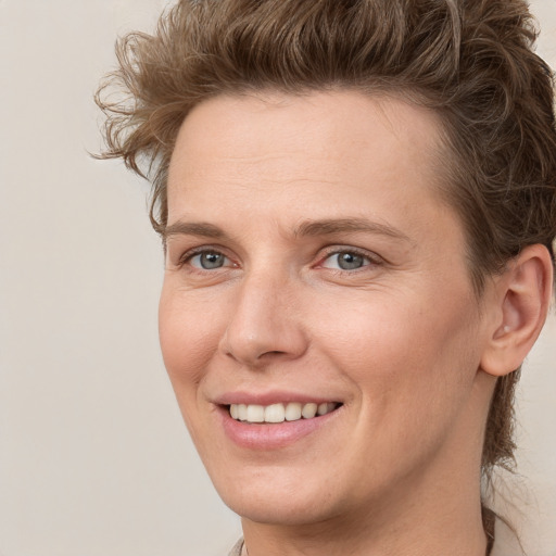 Joyful white young-adult female with short  brown hair and grey eyes