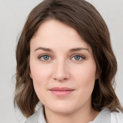 Joyful white young-adult female with medium  brown hair and green eyes