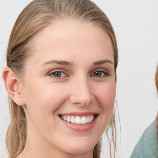 Joyful white young-adult female with medium  brown hair and grey eyes