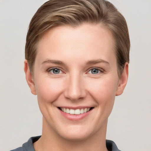 Joyful white young-adult female with short  brown hair and grey eyes