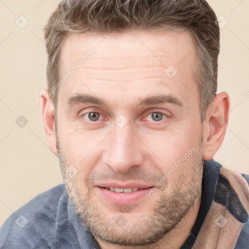 Joyful white adult male with short  brown hair and grey eyes