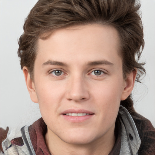 Joyful white young-adult male with medium  brown hair and grey eyes