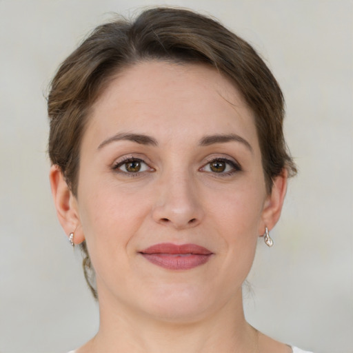 Joyful white young-adult female with short  brown hair and green eyes