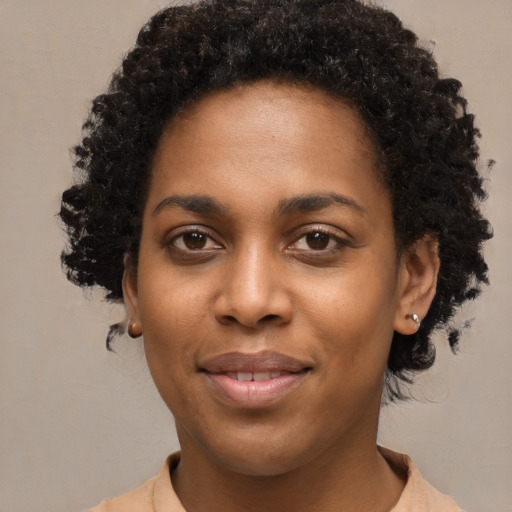 Joyful black young-adult female with short  black hair and brown eyes