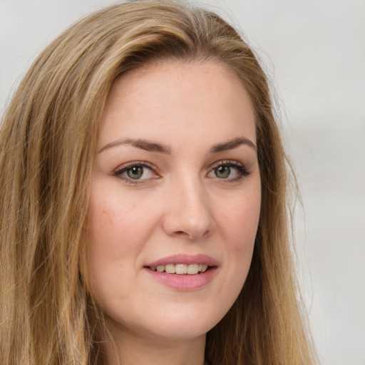 Joyful white young-adult female with long  brown hair and green eyes