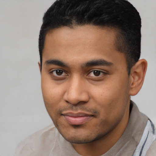 Joyful black young-adult male with short  black hair and brown eyes