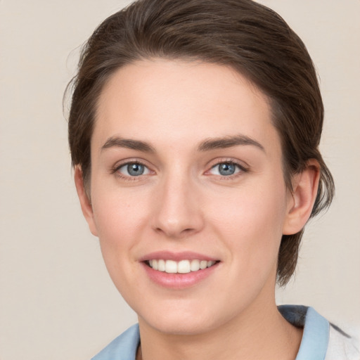 Joyful white young-adult female with medium  brown hair and grey eyes