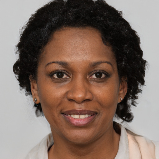 Joyful black adult female with short  brown hair and brown eyes