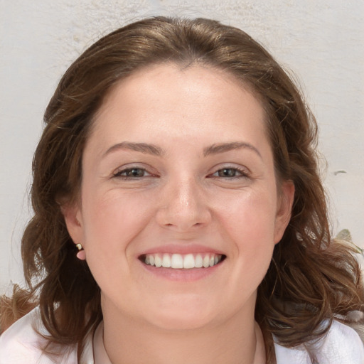 Joyful white young-adult female with medium  brown hair and blue eyes