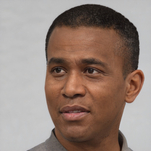 Joyful black adult male with short  black hair and brown eyes