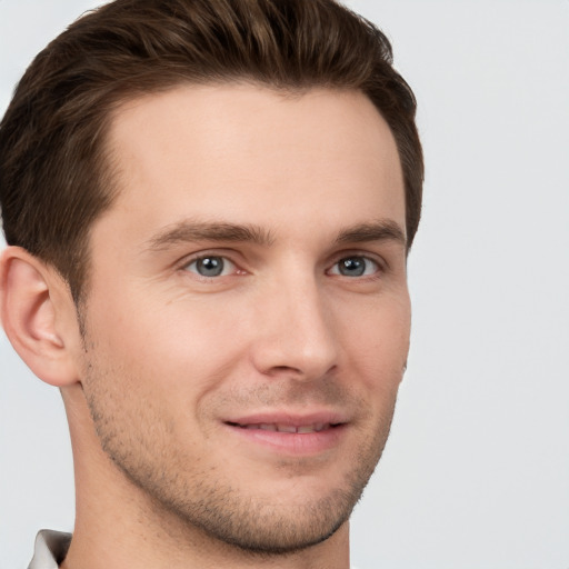 Joyful white young-adult male with short  brown hair and grey eyes