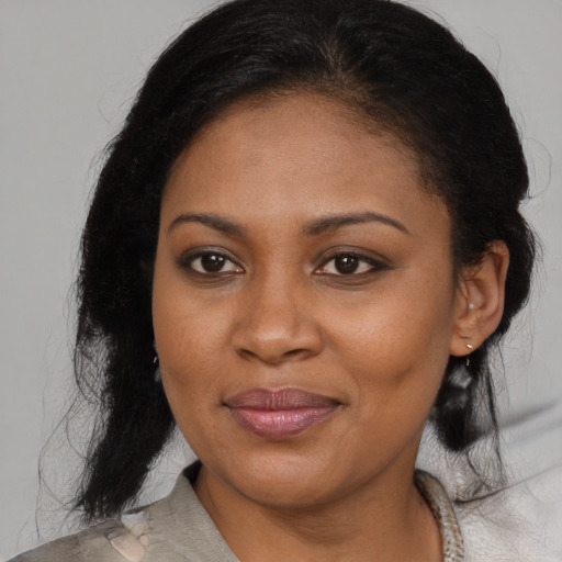 Joyful black young-adult female with medium  brown hair and brown eyes