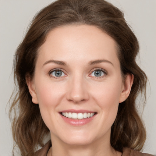 Joyful white young-adult female with medium  brown hair and grey eyes