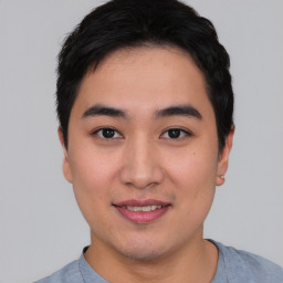 Joyful asian young-adult male with short  black hair and brown eyes