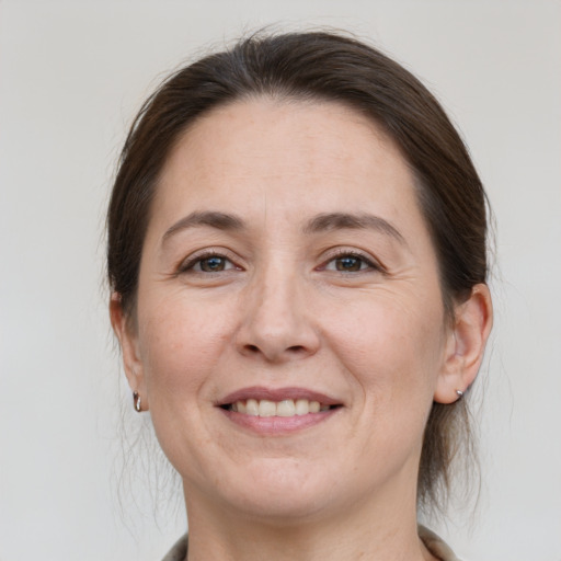 Joyful white adult female with medium  brown hair and grey eyes