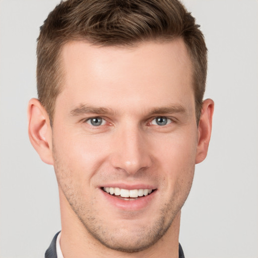 Joyful white young-adult male with short  brown hair and grey eyes