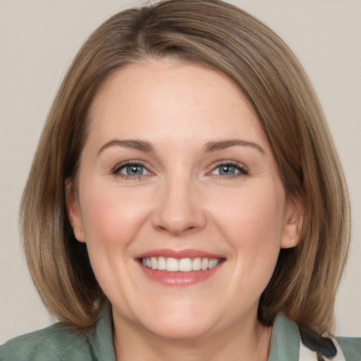 Joyful white adult female with medium  brown hair and grey eyes