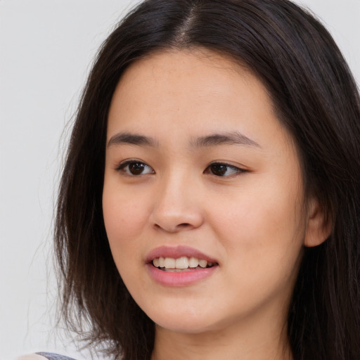 Joyful asian young-adult female with long  brown hair and brown eyes
