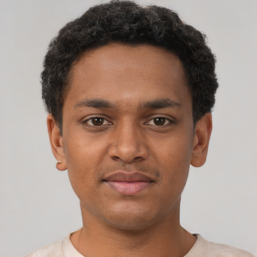 Joyful black young-adult male with short  brown hair and brown eyes