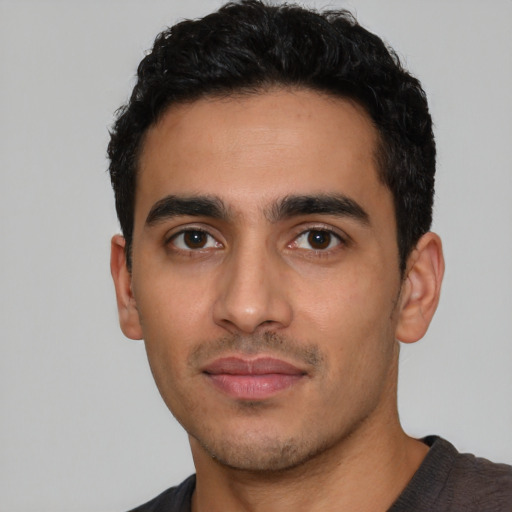 Joyful latino young-adult male with short  black hair and brown eyes