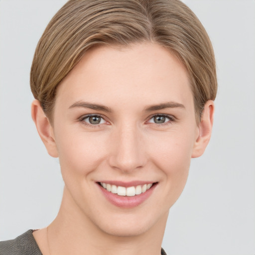 Joyful white young-adult female with short  brown hair and grey eyes