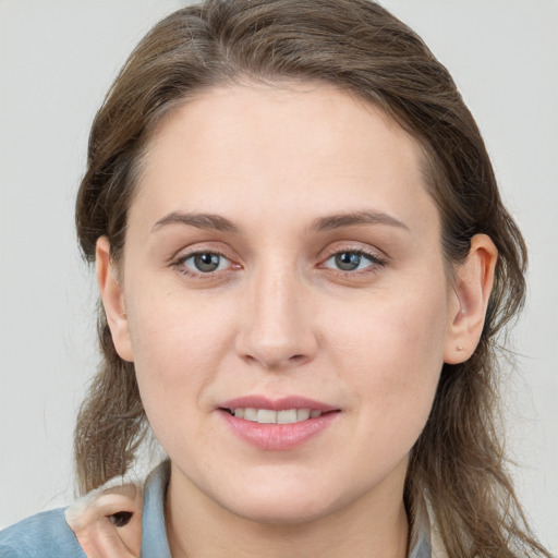 Joyful white young-adult female with long  brown hair and grey eyes