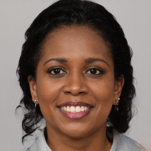 Joyful black adult female with medium  brown hair and brown eyes