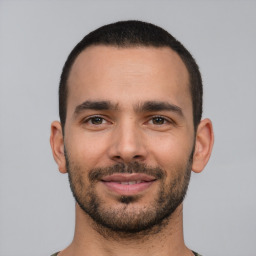 Joyful white young-adult male with short  black hair and brown eyes