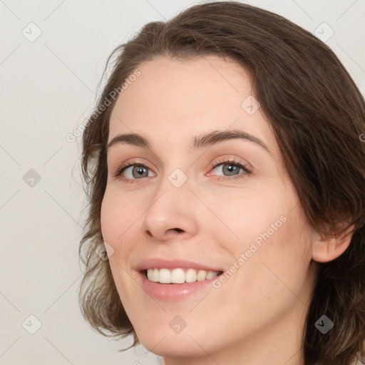 Joyful white young-adult female with medium  brown hair and green eyes