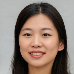 Joyful asian young-adult female with long  brown hair and brown eyes